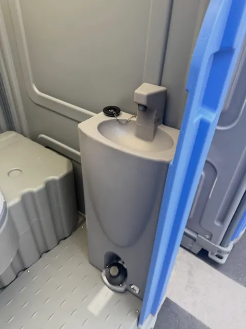 Interior of a deluxe porta potty with a built-in foot-pump sink