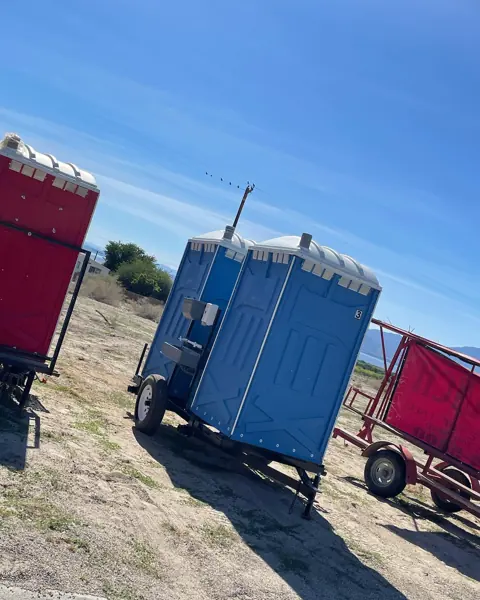 Small restroom trailers parked in a yard ready for delivery